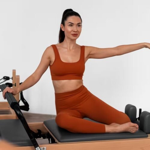 Woman achieving full body control on Reformer; reflects Pilates mastery, precision, and elite wellness status in Spain.