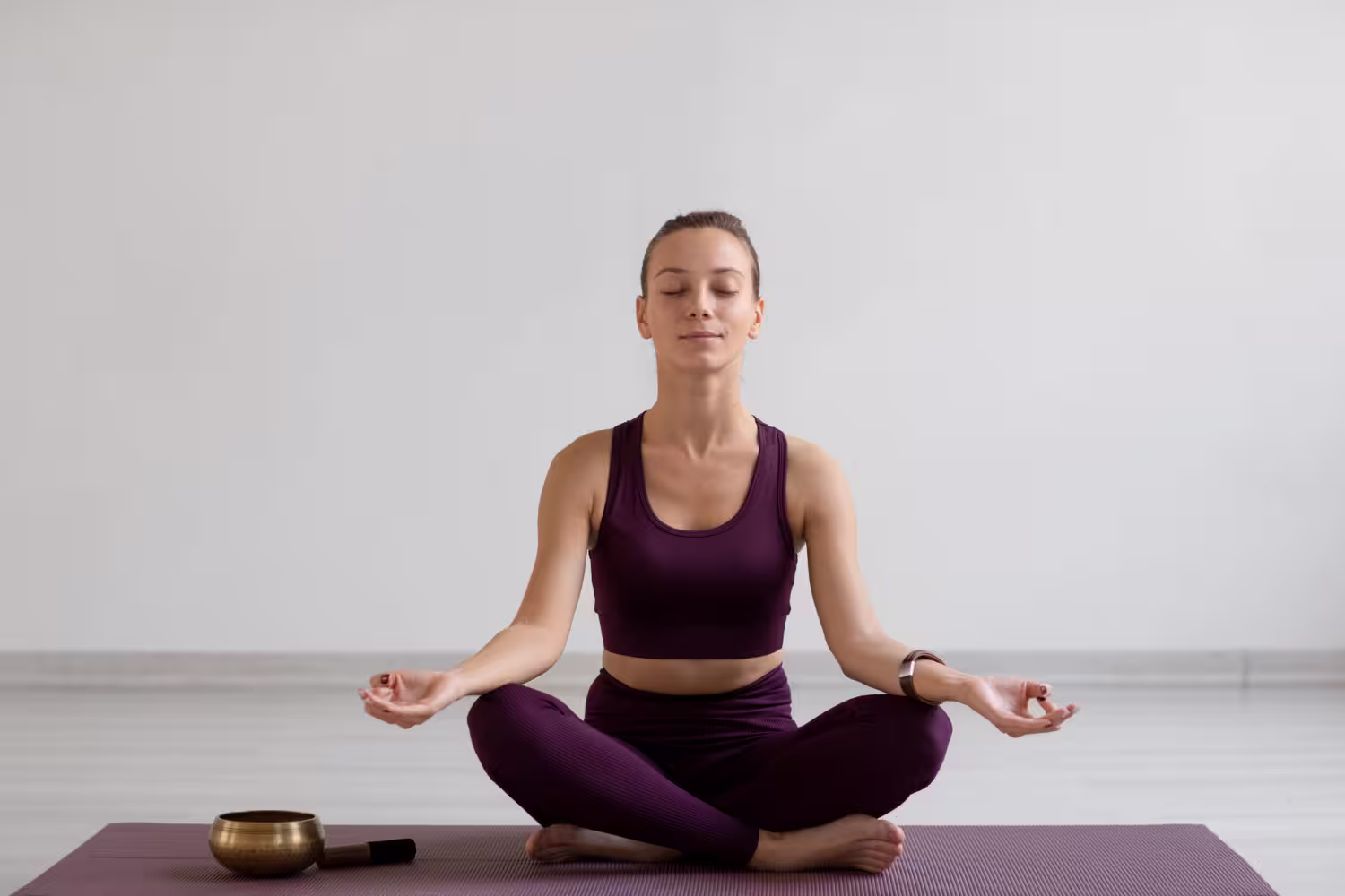 Woman meditating in yoga pose; reflects centered mind, home balance, and wellness capital status.